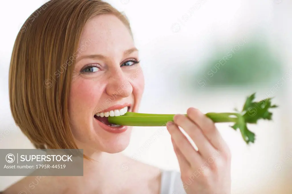 USA, New Jersey, Jersey City, woman eating fresh celery