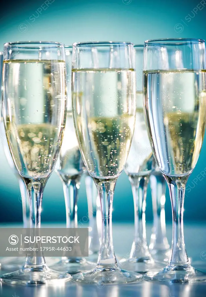 Close up of champagne flutes on blue background