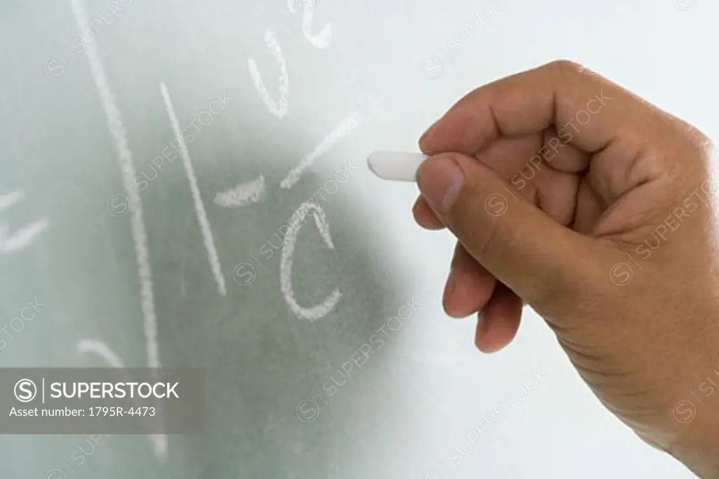Close-up of blackboard with math equations being written on it