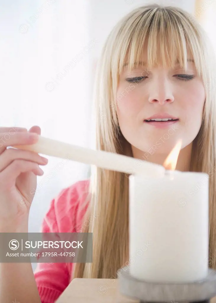 USA, New Jersey, Jersey City, young woman igniting candle