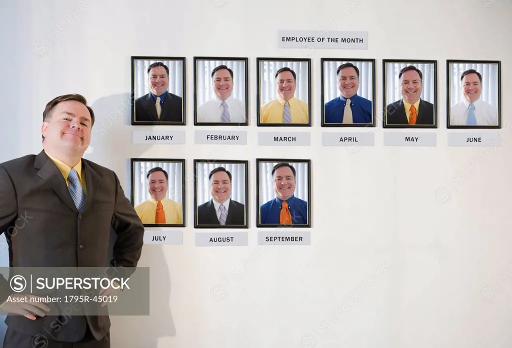 USA, Jersey City, New Jersey, businessman standing in front of employee of the month portraits