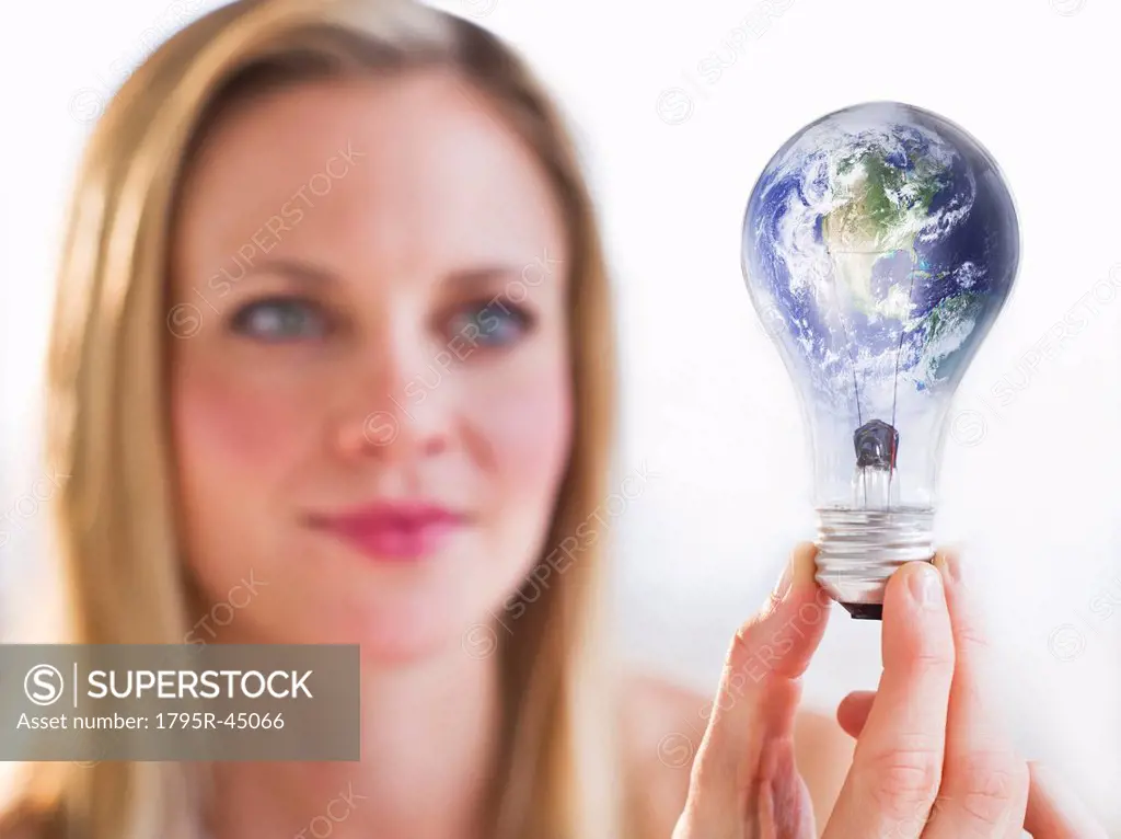 Woman holding lightbulb with globe