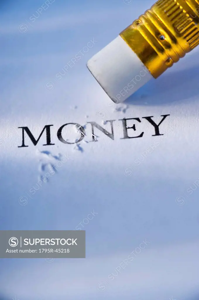 Studio shot of pencil erasing the word money from piece of paper