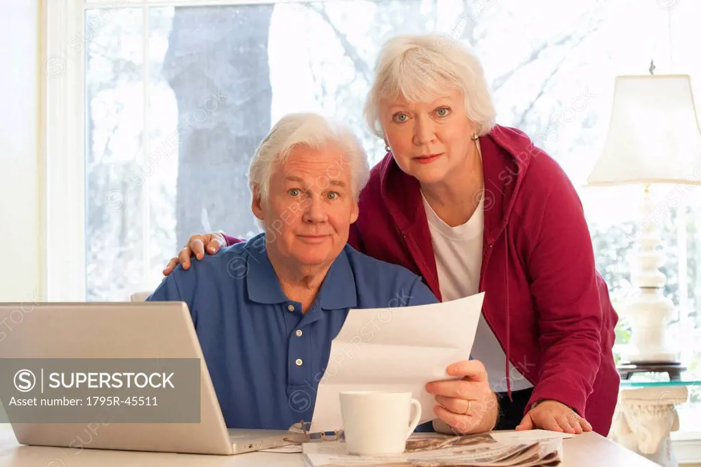 USA, Virginia, Richmond, portrait of senior couple paying bills with laptop