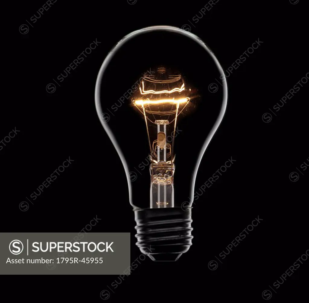 Energy saving bulb on black background, studio shot