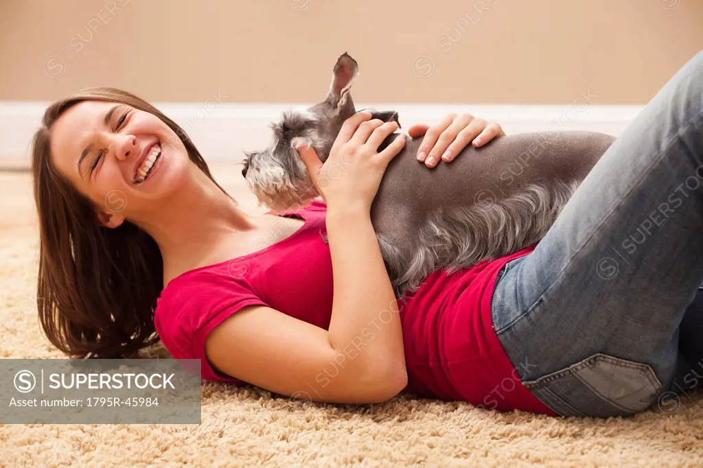 Young woman playing with schnauzer