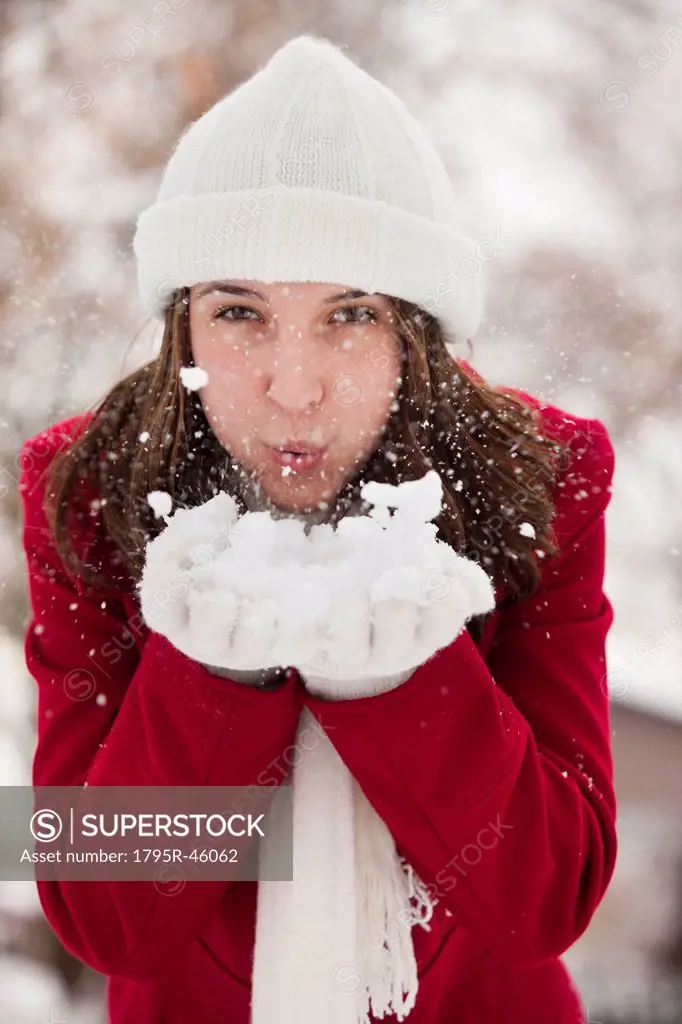 USA, Utah, Lehi, Portrait of young woman blowing snow