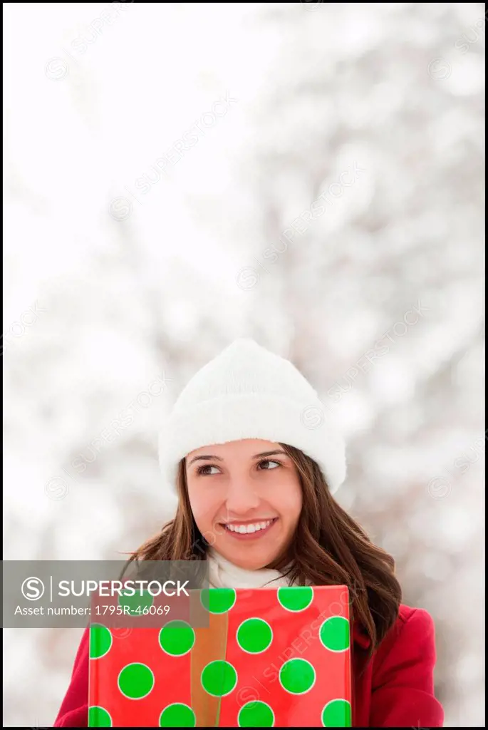 USA, Utah, Lehi, Young woman holding Christmas gift outdoors