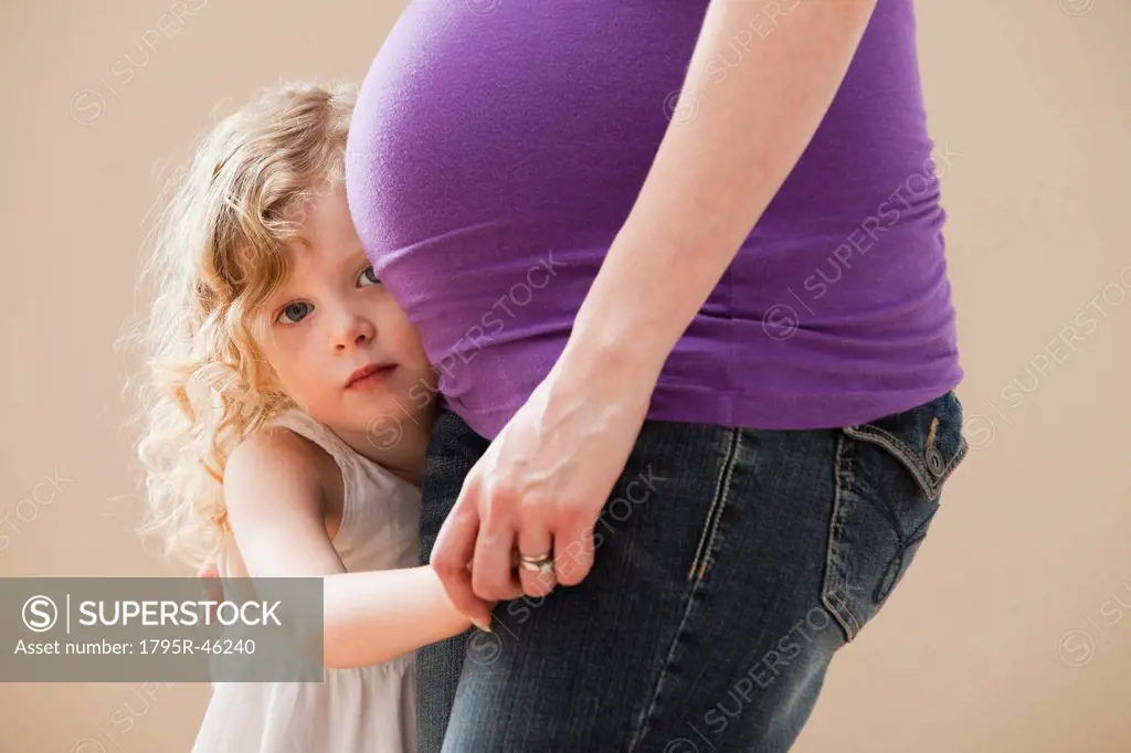 USA, Utah, Lehi, Girl 2_3 peeking form behind pregnant mother´s belly