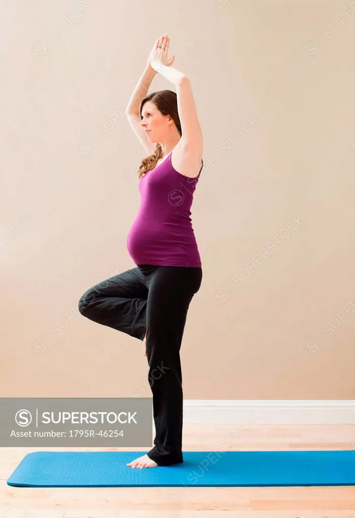 USA, Utah, Lehi, Young pregnant woman exercising, standing on one leg