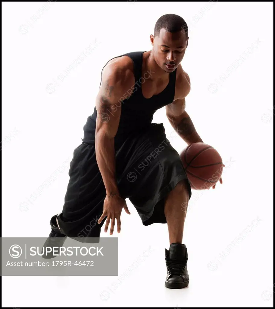 Studio shot of man playing basketball