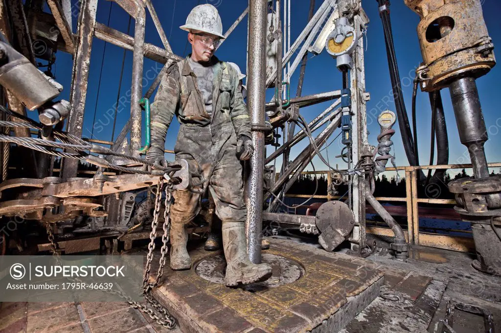 Canada, Alberta, Oil workers using oil drill