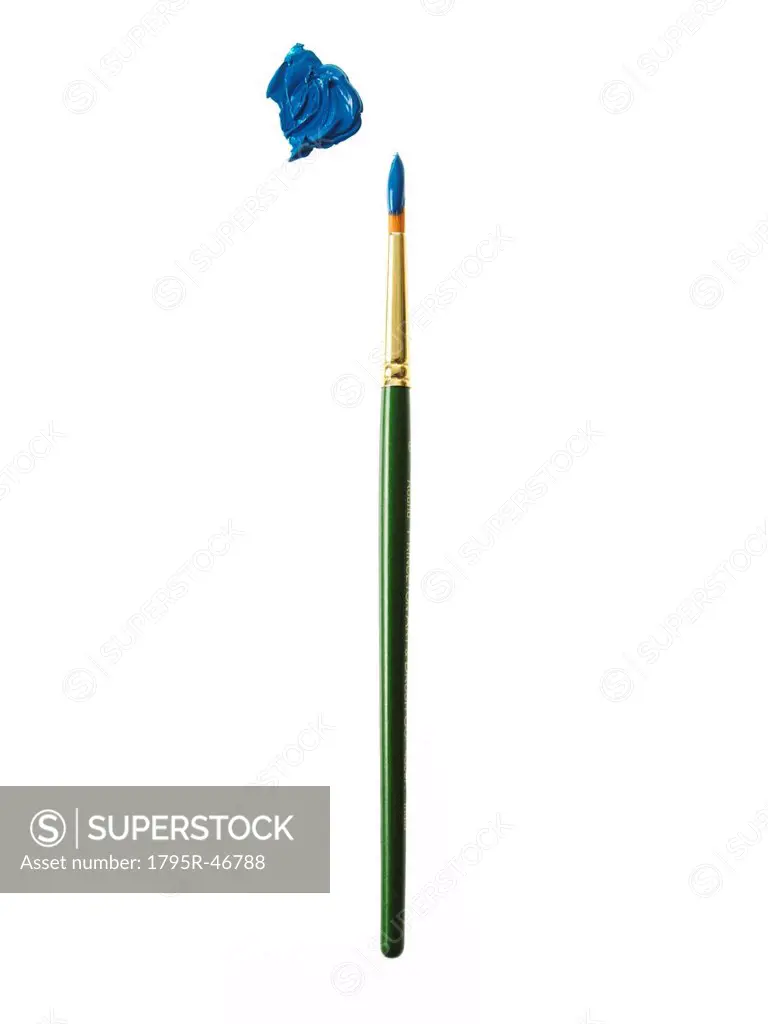 Green paintbrush with blue paint on white background