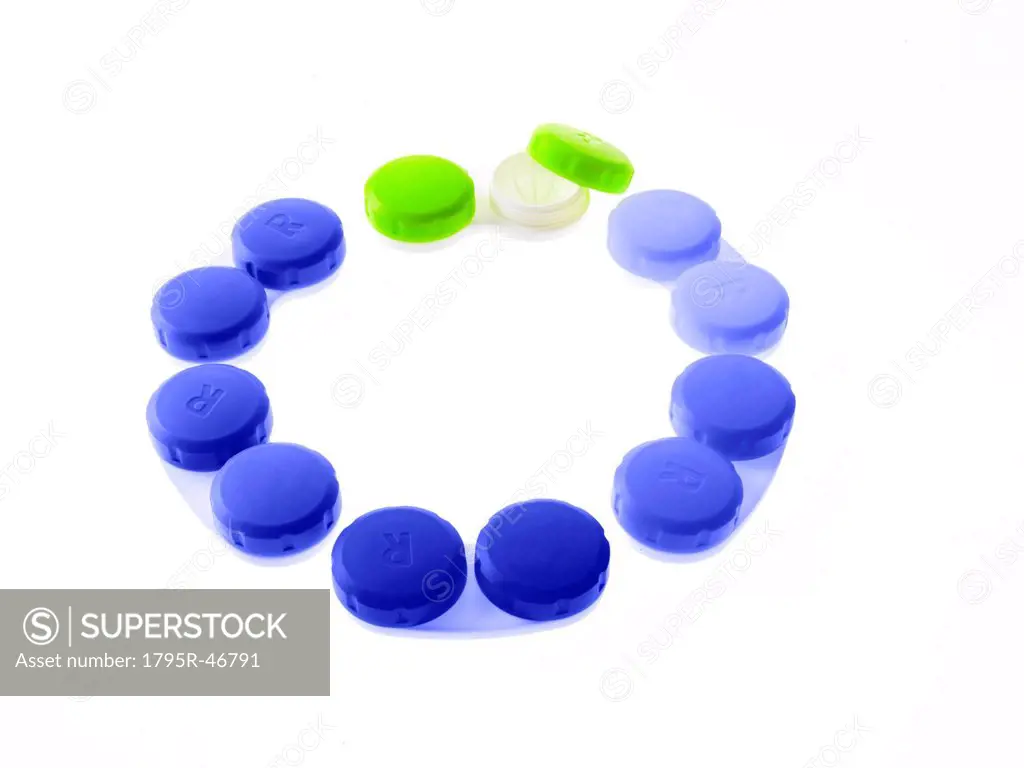 Blue and green contact lens cases on white background