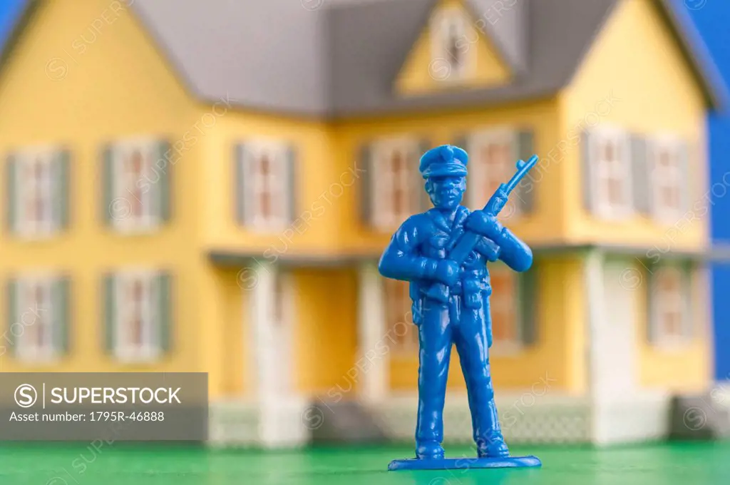 Figurine of soldier in front of model of house
