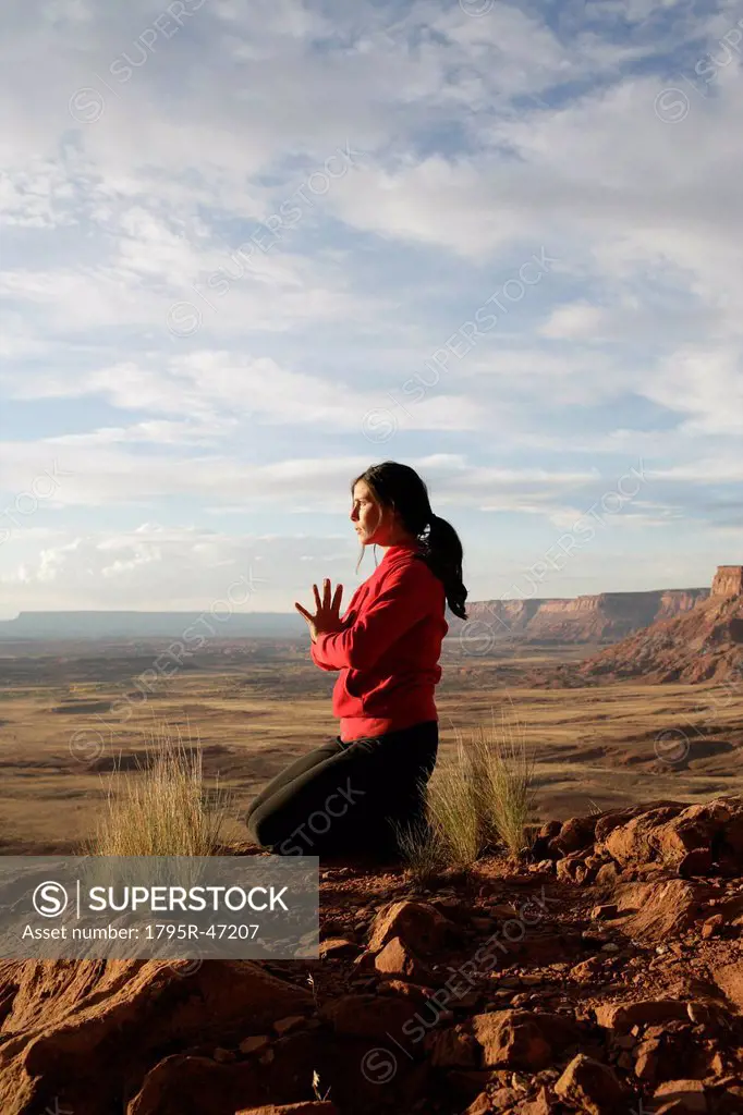 USA, Utah, Canyonlands National Park, woman meditating on rock