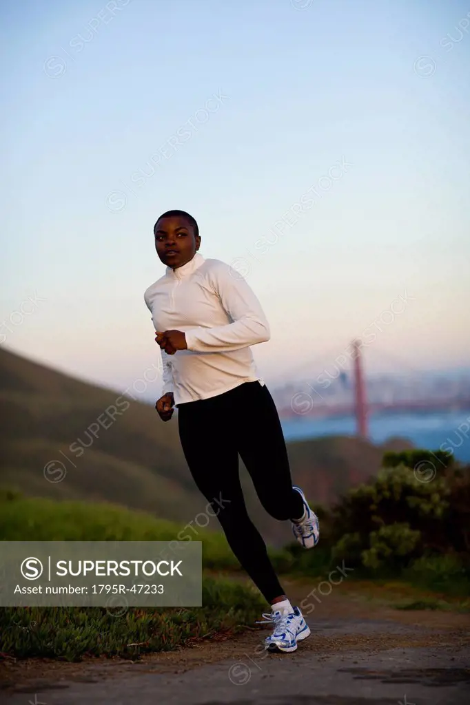 USA, California, San Francisco, Woman jogging, Golden Gate Bridge in background