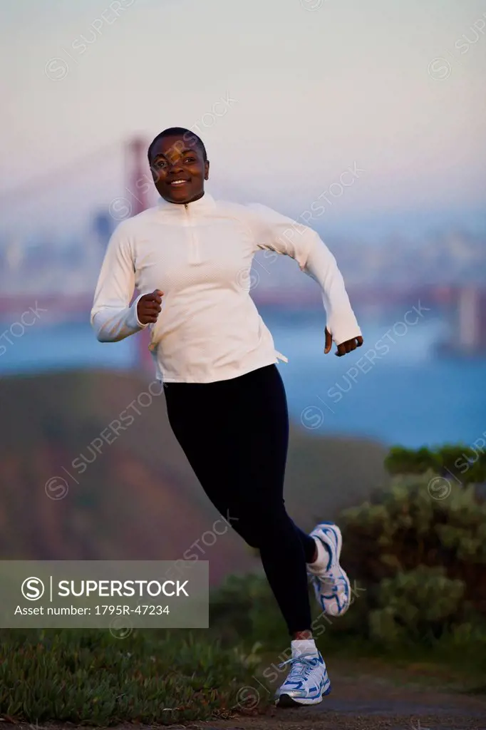 USA, California, San Francisco, Woman jogging, Golden Gate Bridge in background
