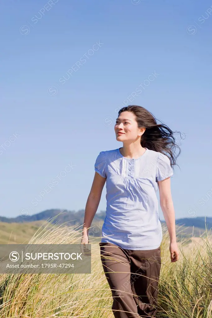 USA, California, Point Reyes, Young woman walking in grass