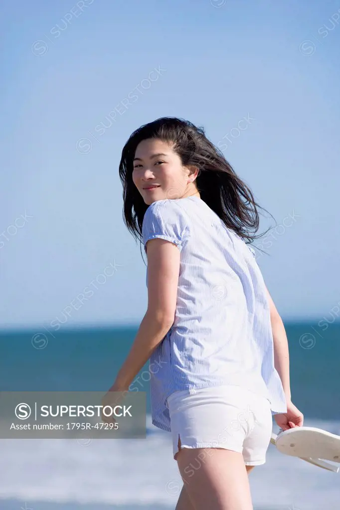 USA, California, Point Reyes, Young woman walking near sea