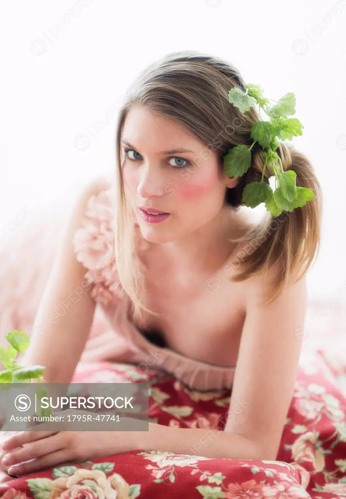 Studio portrait of young woman with flowers in hair