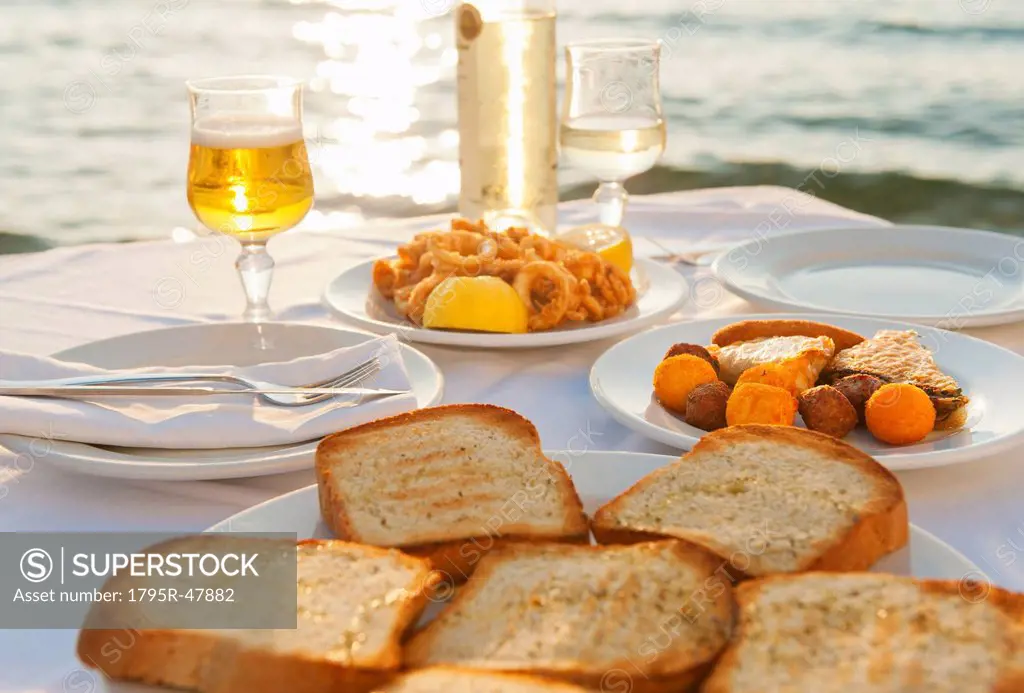 Greece, Cyclades Islands, Mykonos, Calamari appetizer on set table by sea