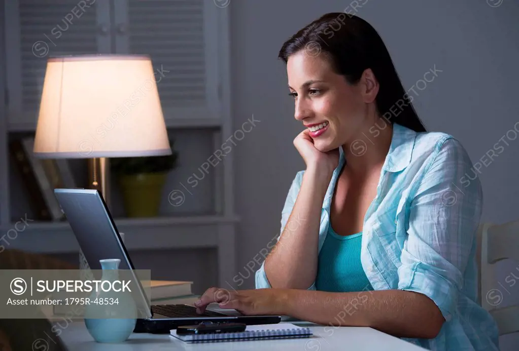 Woman using laptop at night