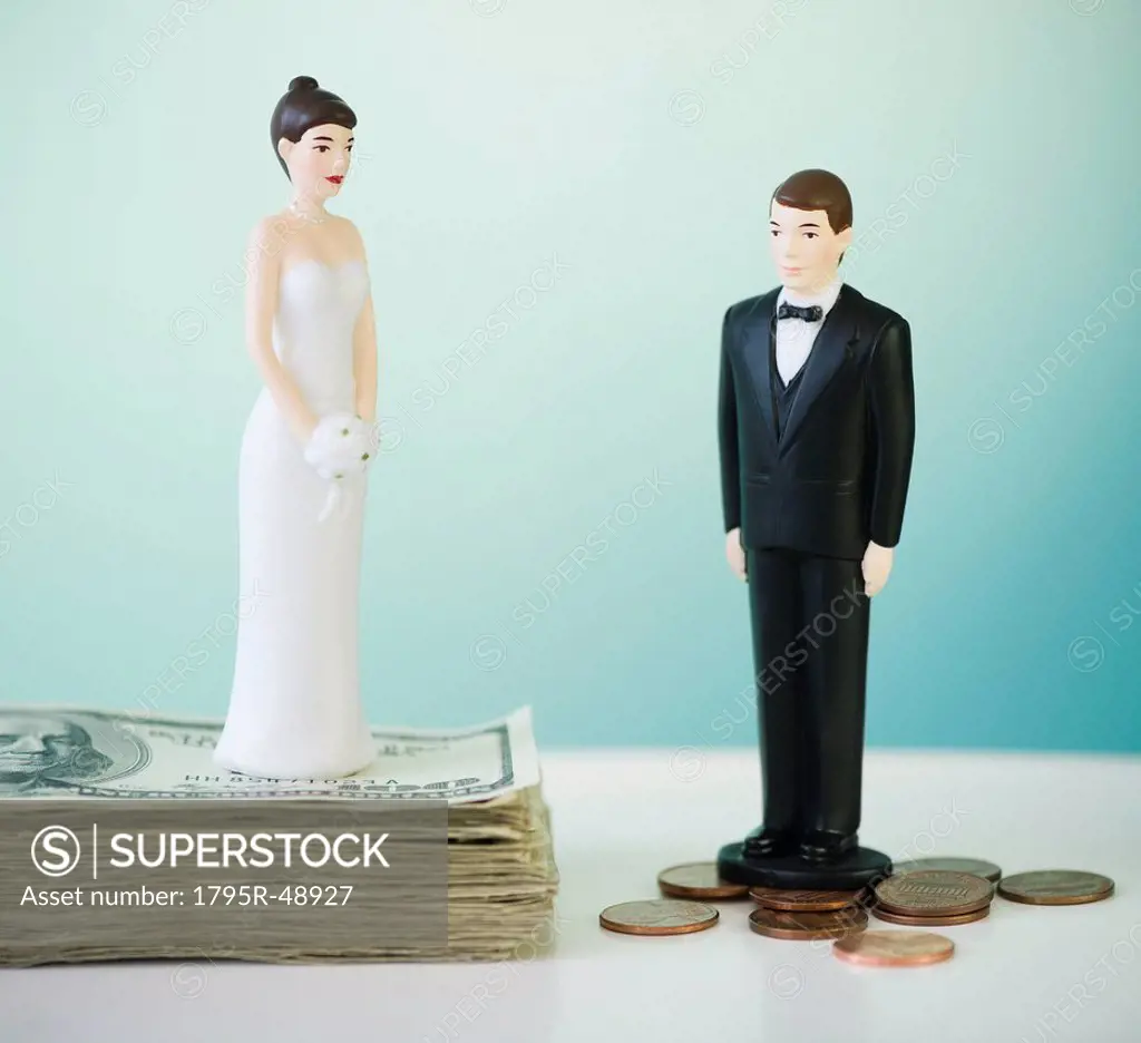 Close up of wedding cake figurines on coins and banknotes