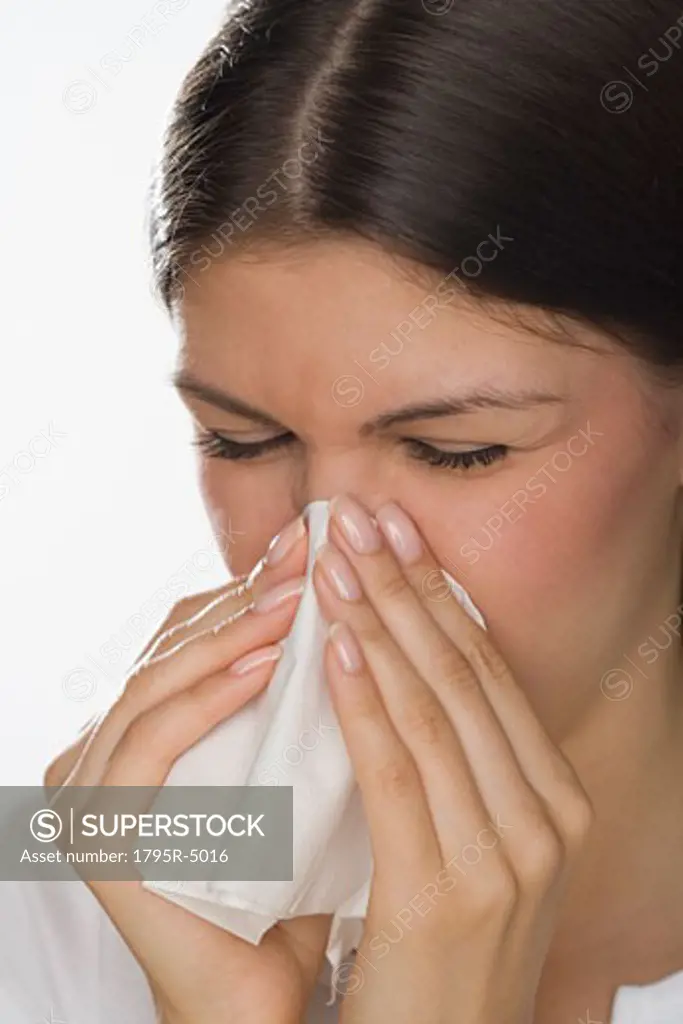 Close-up of woman blowing nose