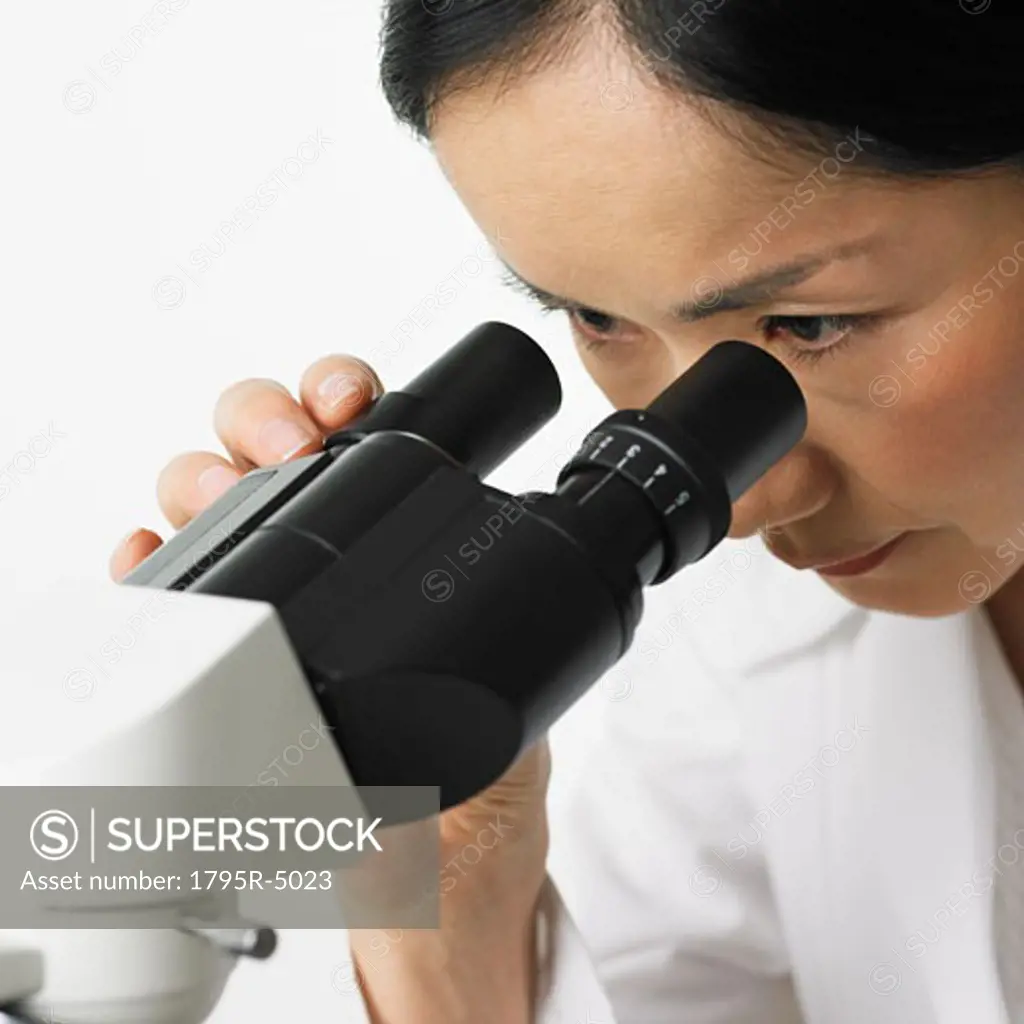 Close-up of woman looking in microscope
