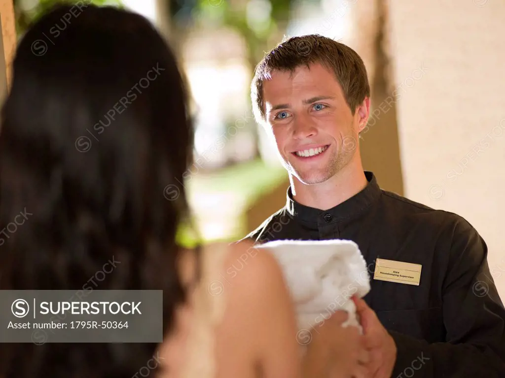 Man from room service delivering towels to hotel guest