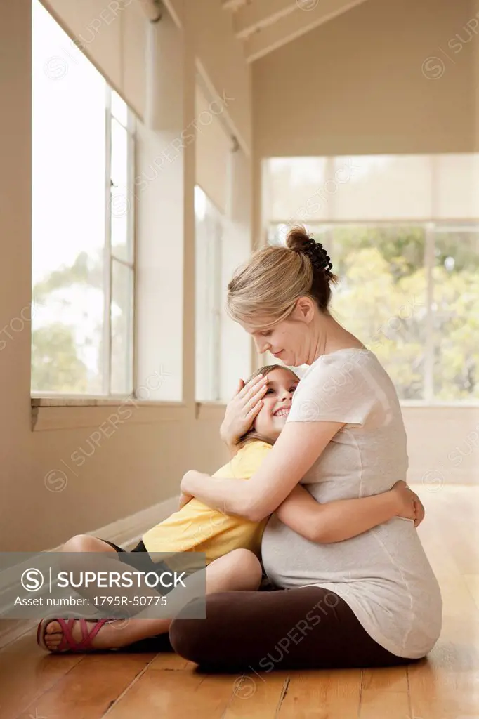 Daughter embracing 6_7 pregnant mother