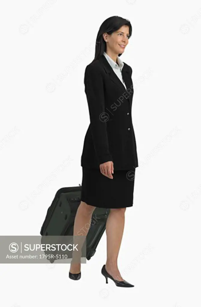 Studio shot of businesswoman pulling suitcase