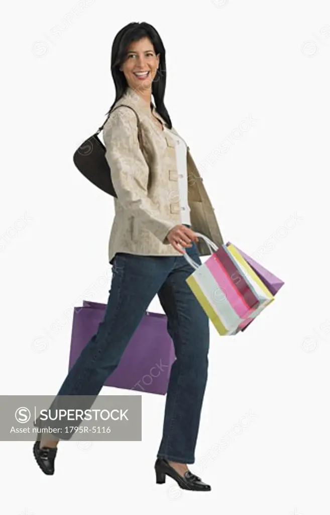 Studio shot of woman carrying shopping bags