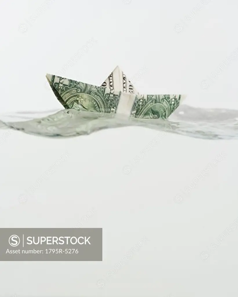 Boat made of US dollar floating on water