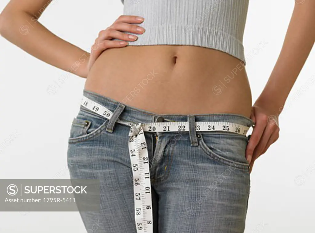 Woman with bare midriff using tape measure as belt
