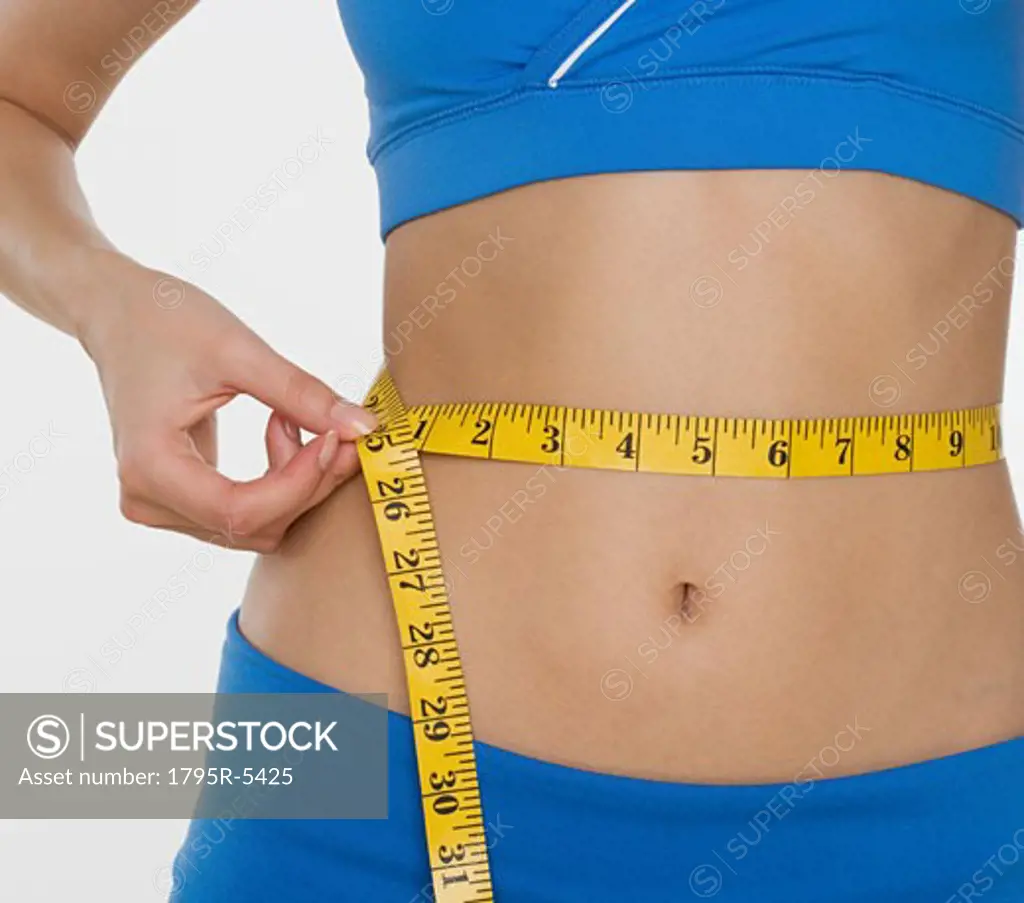 Woman in athletic gear measuring waist