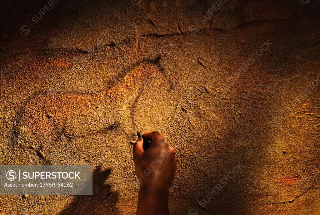 Studio shot of hand making cave painting of horse