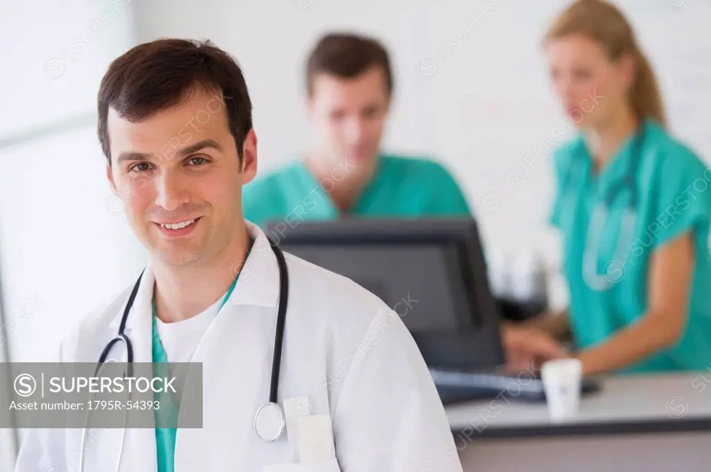 Portrait of male doctor in front of nurse´s station