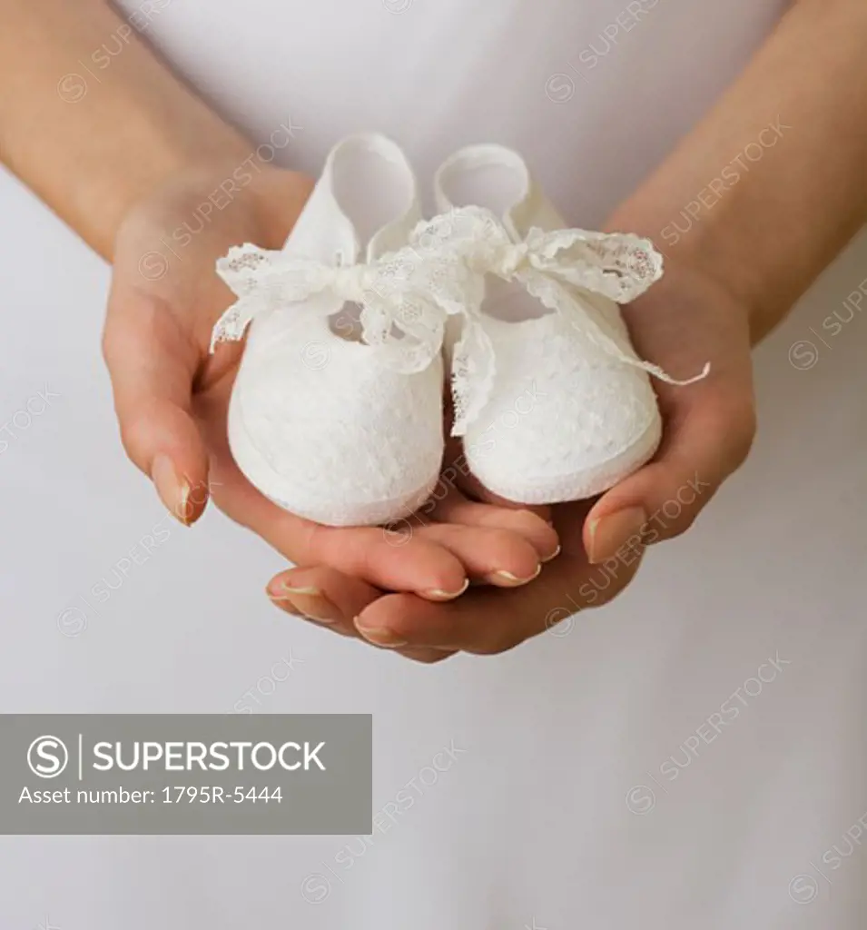 Close-up of woman holding baby shoes