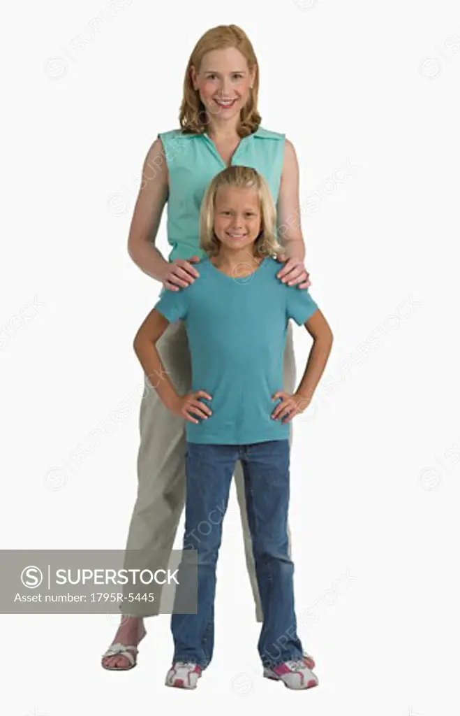 Studio shot of mother resting hands on daughter's shoulders