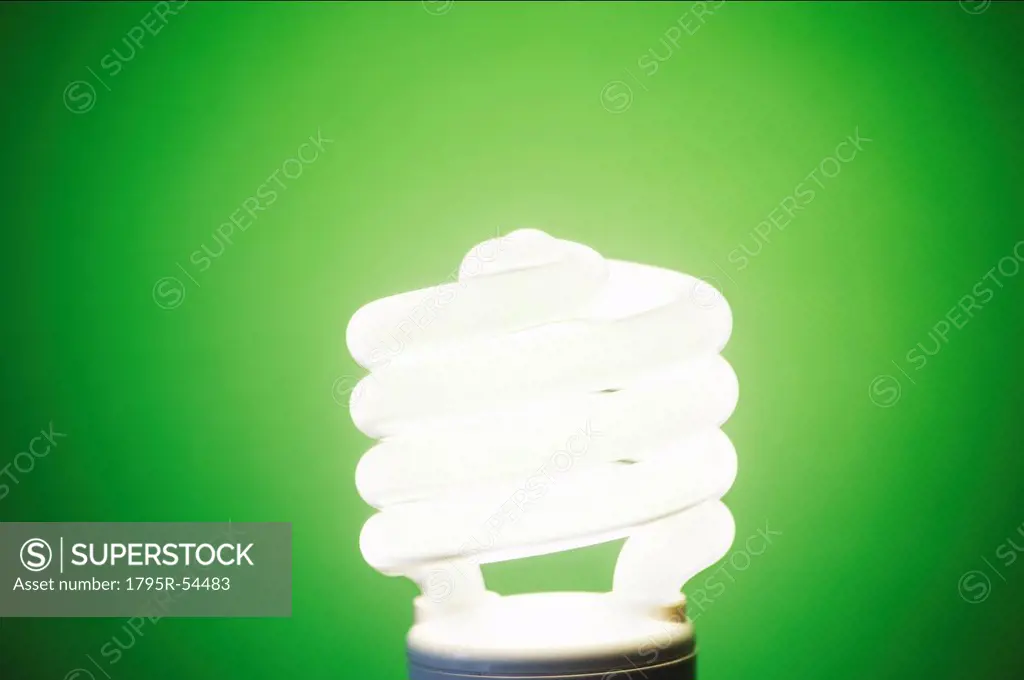 Studio shot of energy efficient lightbulb on green background