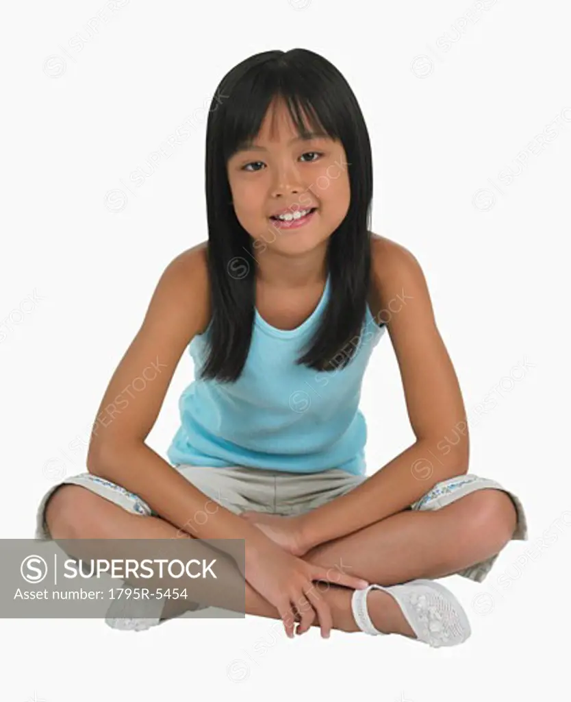 Studio shot of girl sitting cross-legged