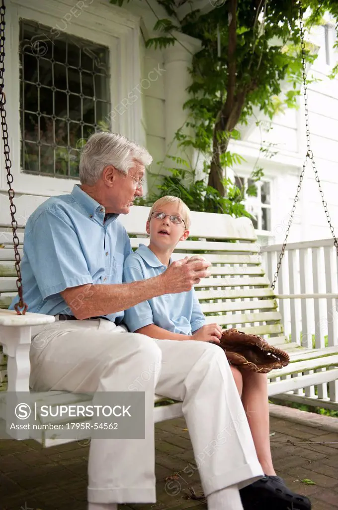 Grandfather and grandson 10_11 sitting on porch swing