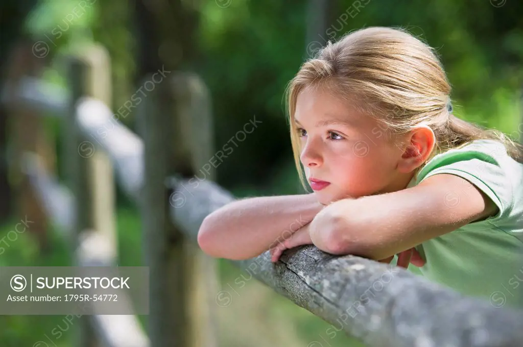 Girl 10_11 leaning on fence