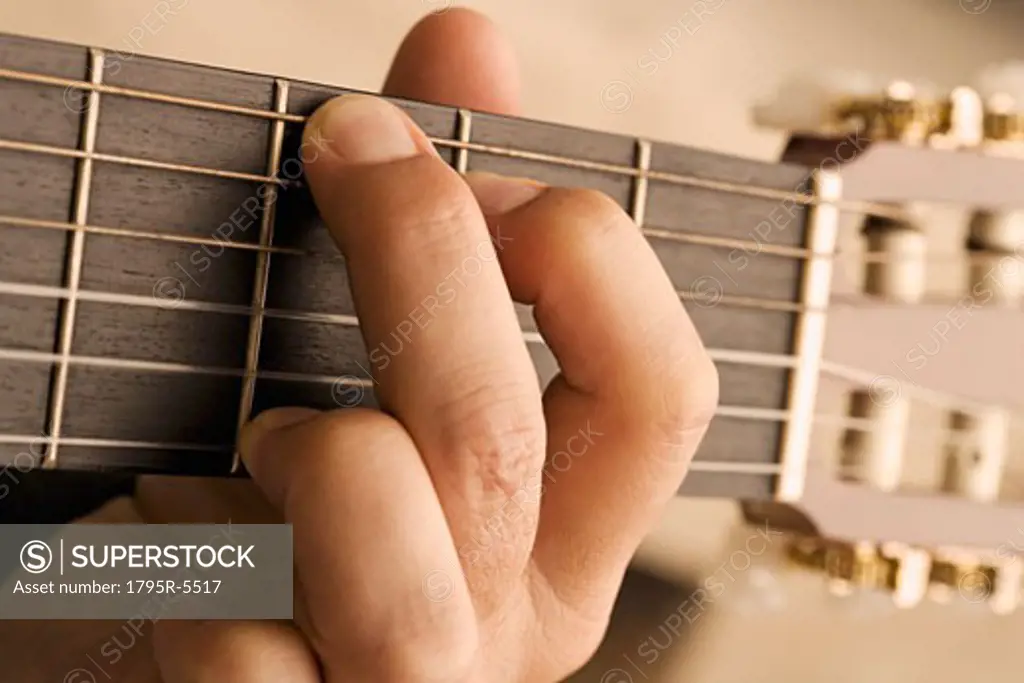 Close-up of man's hand playing guitar