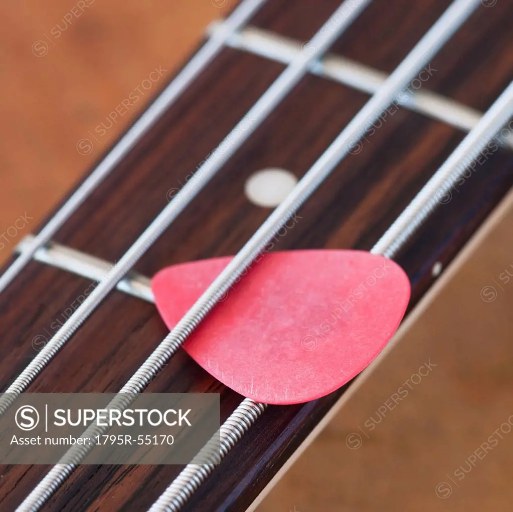 Close_up of bass guitar with guitar pick