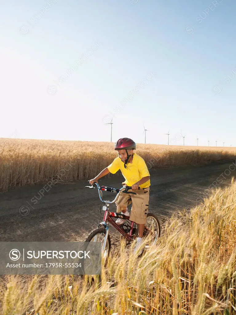 Boy 8_9 cycling along dirt road