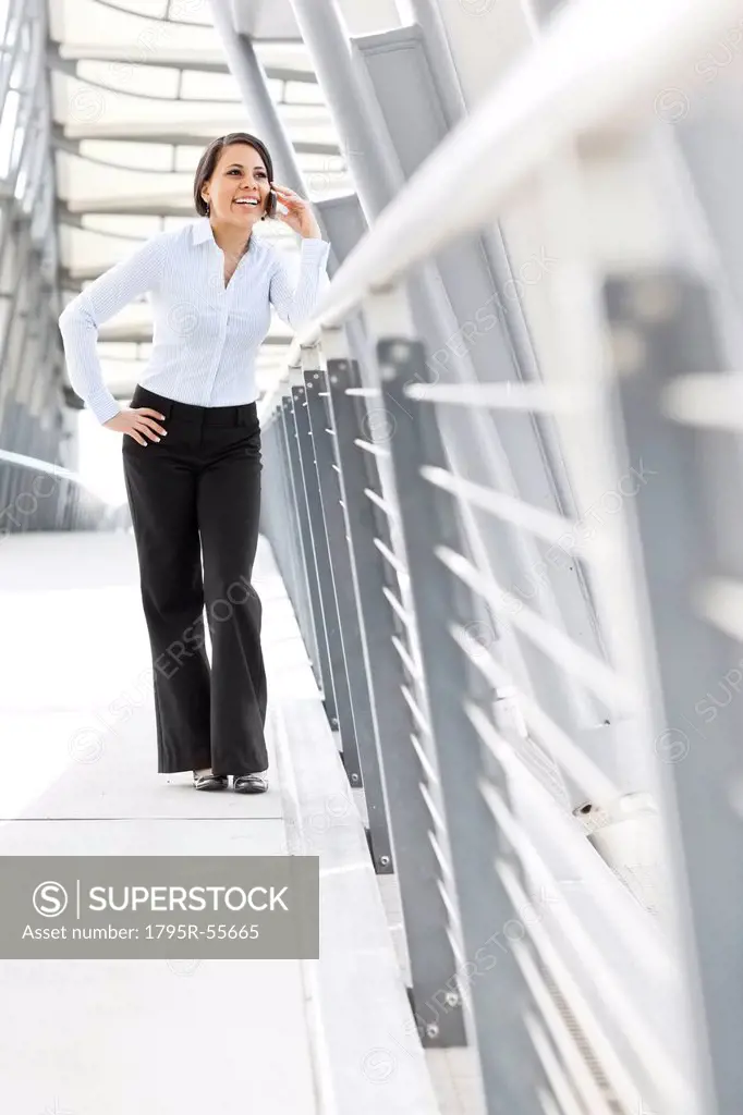Young businesswoman on walkway, using cell phone