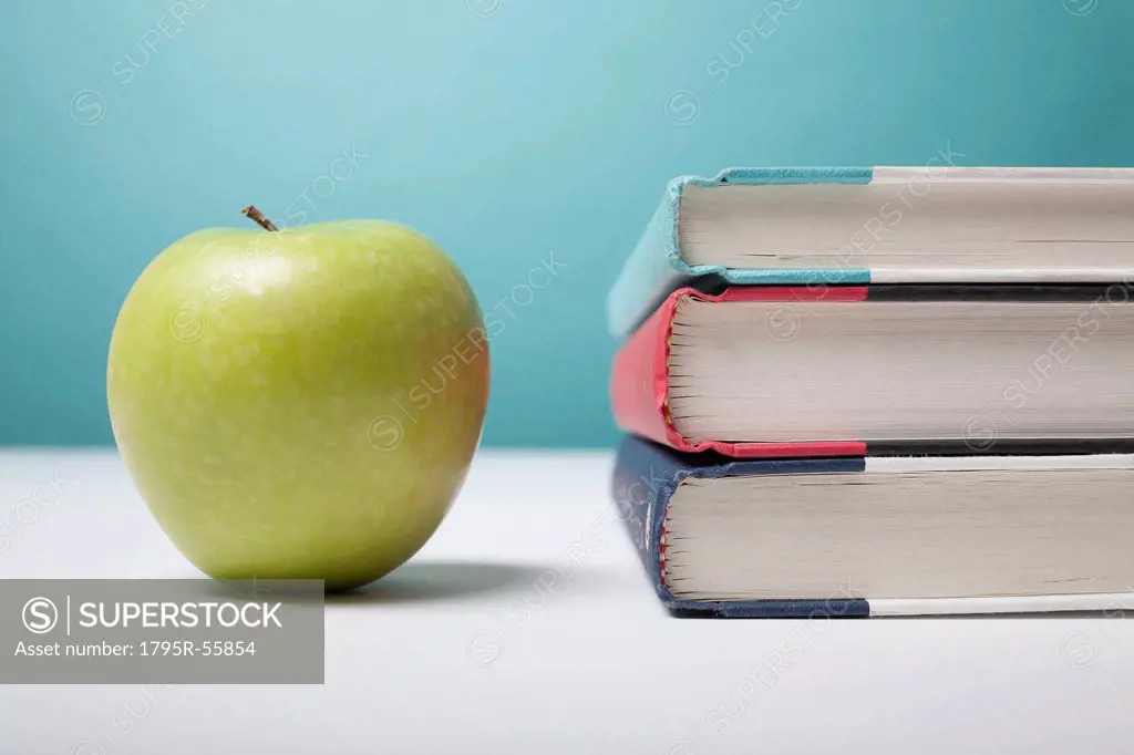 Studio shot of green apple and textbooks